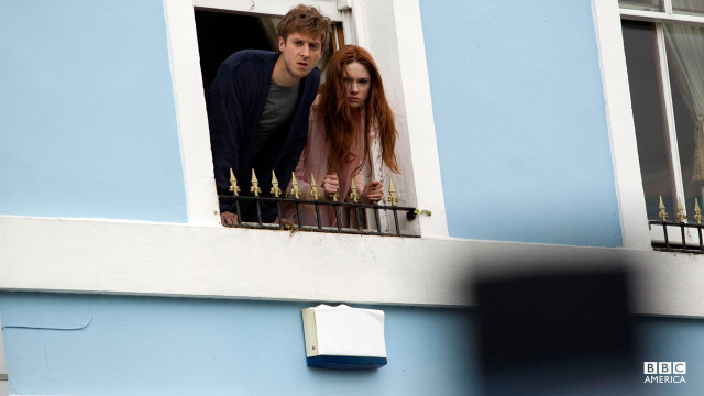 Amy and Rory looking outside of their window.