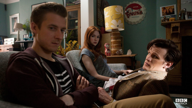 The Doctor, Amy, and Rory sitting on a couch.