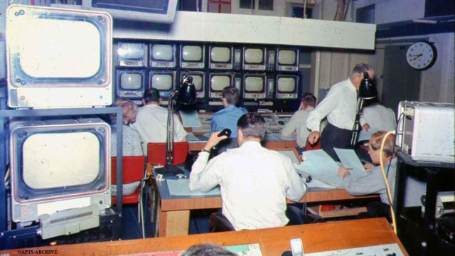 Studio B Control Gallery – opposite view of above photograph. The bank of monitor screens are clearly visible in the background, to which all those in the control room watch constantly. The control room engineer is sitting in the immediate foreground.