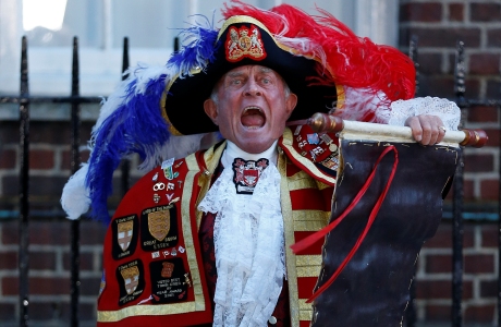 Tony Appleton, a town crier, announces the birth of the royal baby, outside St. Mary's Hospital exclusive Lindo Wing in London, Monday, July 22, 2013. Palace officials say Prince William's wife Kate has given birth to a baby boy. The baby was born at 4:24 p.m. and weighs 8 pounds 6 ounces. The infant will become third in line for the British throne after Prince Charles and William. (AP Photo/Lefteris Pitarakis)