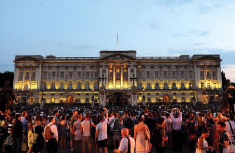 Members of the public celebrate outside Buckingham Palace after an easel was placed in the forecourt of the Palace with the notification to announce the birth of a baby boy, at 4.24pm to the Duke and Duchess of Cambridge at St Mary's Hospital in west London, Monday July 22, 2013.(AP Photo/Clive Gee, PA)