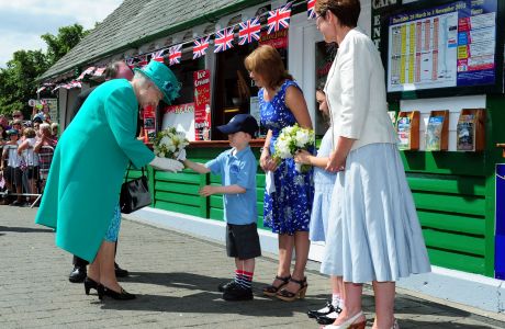 Queen Elizabeth II is presented with a posy of flowers by Daniel Dixon, aged six, from St Mary's Primary School Windermere, as she arrives at Bowness on Windermere pier, Cumbria. (Press Association via AP Images)