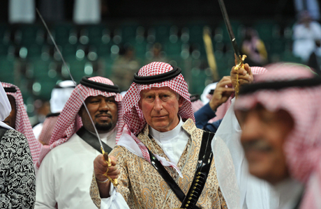 Prince Charles, center, wearing traditional Saudi uniform, dances with a sword during the traditional Saudi dancing best known as 'Arda' performed during Janadriya culture festival at Der'iya in Riyadh, Tuesday, Feb. 18, 2014. Prince Charles arrived in Kingdom of Saudi Arabia on a private visit. (AP Photo/Fayez Nureldine,