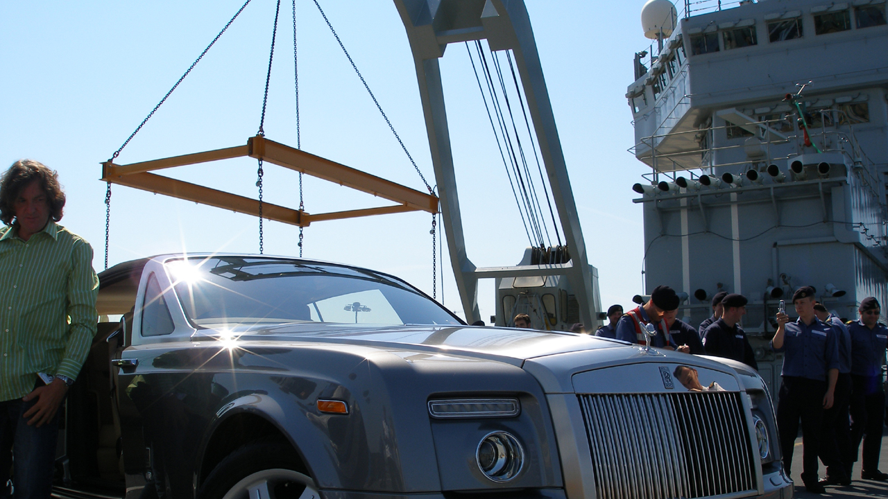 James stands next to the Rolls-Royce Phantom Drophead on the HMS Ark Royal.