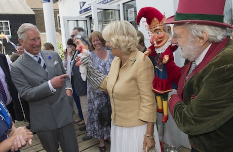 Royal visit to kent. The Prince of Wales and the Duchess of Cornwall with Des Turner the Punch and Judy man at the Whitstable Oyster Festival in Kent. Picture date: Monday July 29, 2013. The Prince of Wales and the Duchess of Cornwall were visiting Whitstable, and Chatham Dockyard as part of a tour of Kent. See PA story ROYAL Charles. Photo credit should read: Arthur Edwards/The Sun/PA Wire URN:17184186 (Press Association via AP Images)