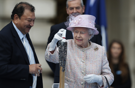Queen Elizabeth II places her message in the baton to travel the Commonwealth. (AP)