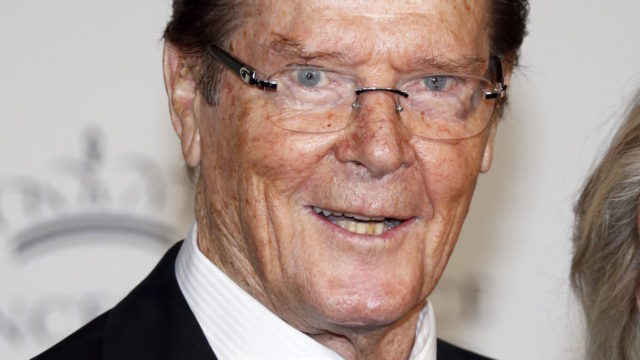 British actor Roger Moore and his wife Cristina Tholstrup pose on the red carpet as they arrive for the 2015 Princess Grace Awards Gala, on September 5, 2015 in Monaco. AFP PHOTO / VALERY HACHE