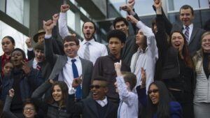 A group of teenagers cheering on steps.